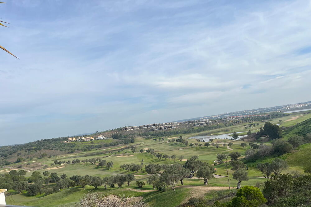Udsigt over en golfbane og landskabet fra en terrasse